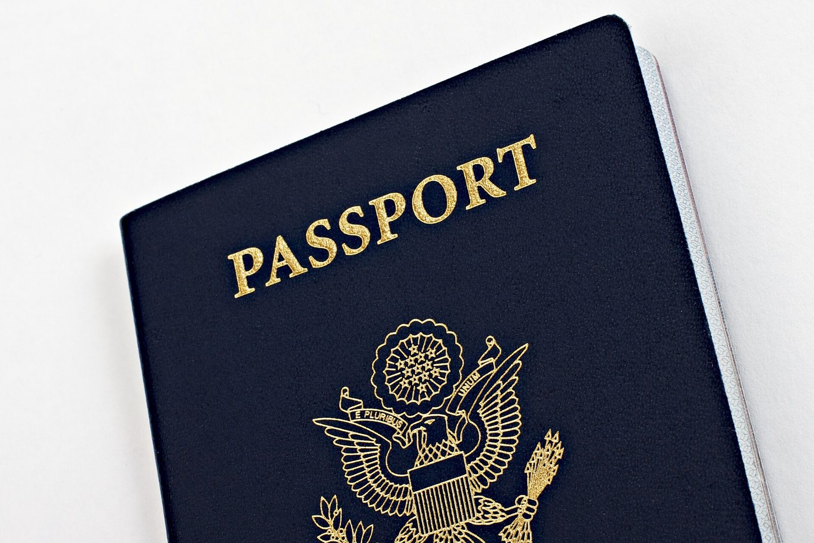 Close-up of the navy blue cover of a United States passport with gold lettering and eagle seal